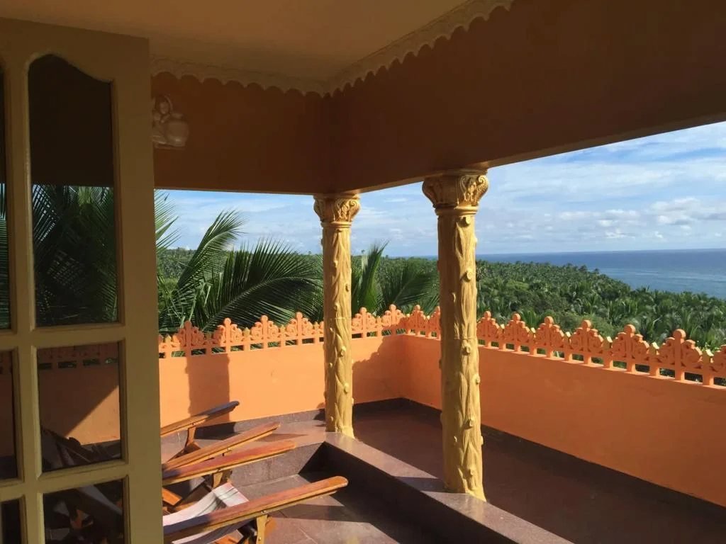 Veranda with carved pillars and a view of the sea