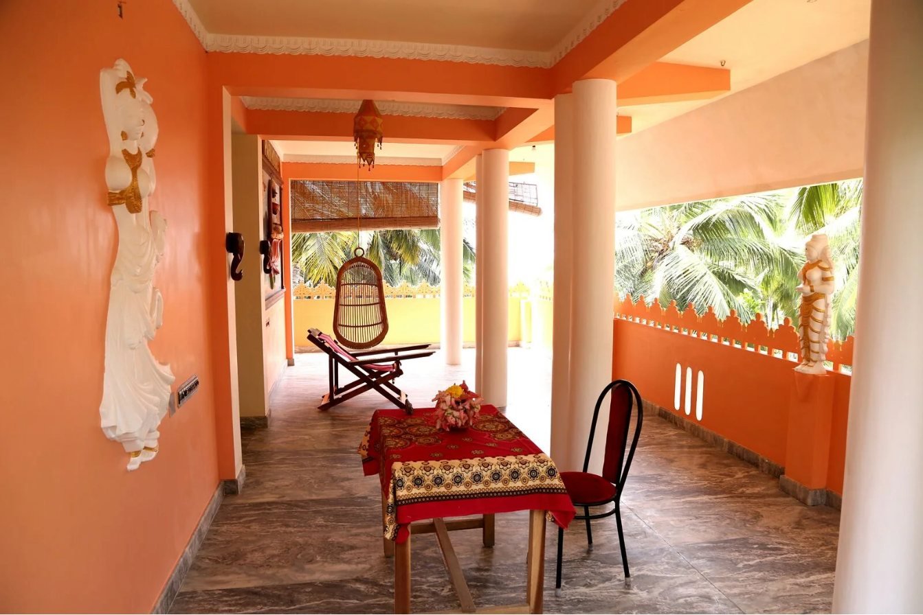 Upper veranda with a swing chair and a table set with flowers